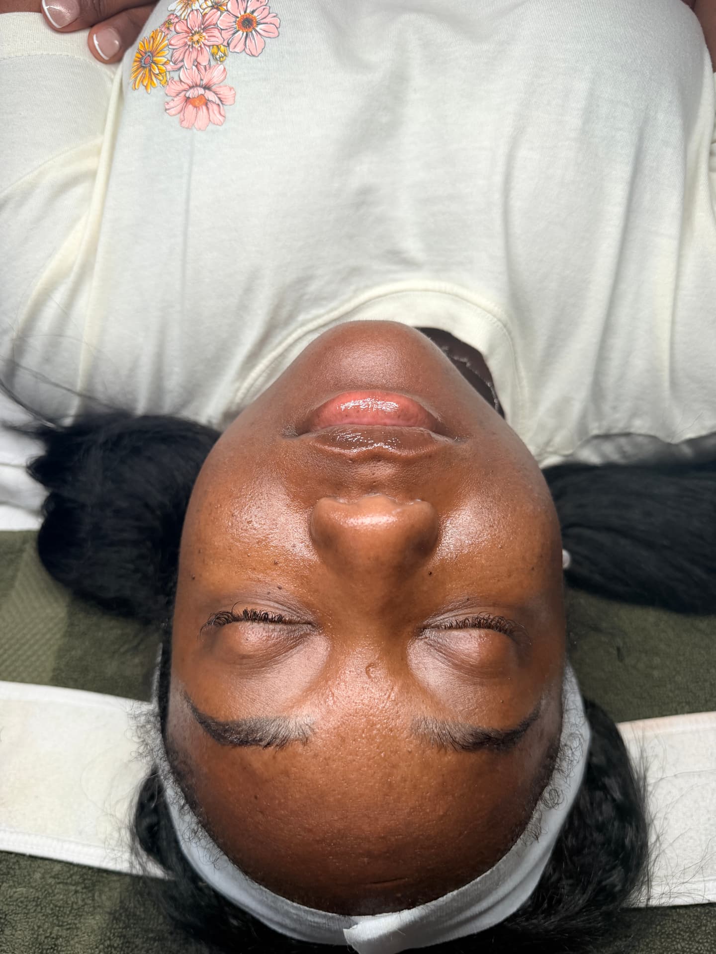 Client with deeper skin tone after a brightening facial, skin looking even and hydrated